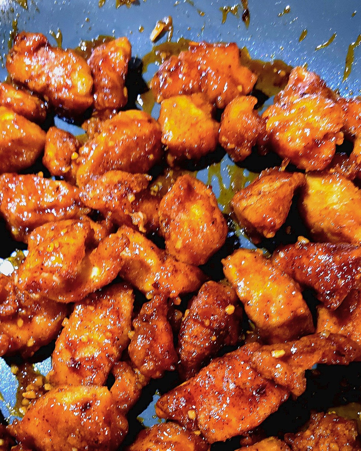 Crispy firecracker chicken tossed in sticky glaze in a skillet