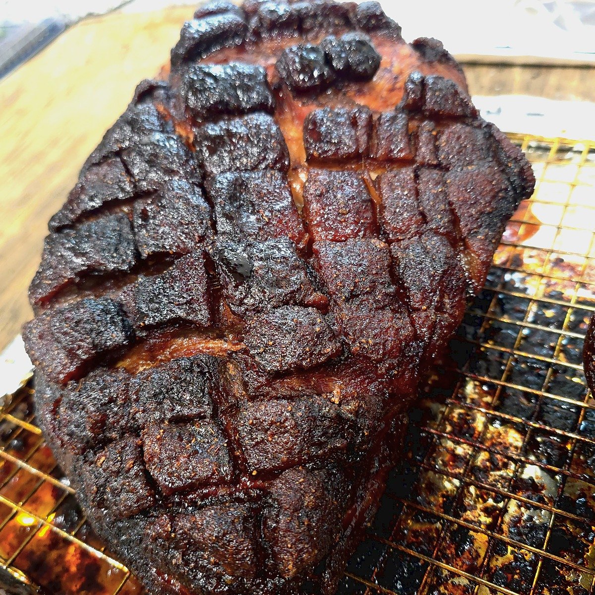 Oven pulled pork roast with a dark, crusty bark and scored crosshatch fat cap on a baking rack